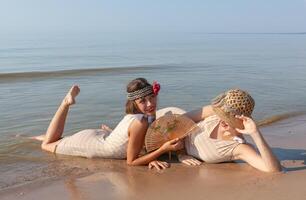 dos joven mujer en retro trajes de baño por el mar foto