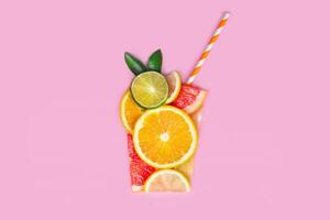 creativo plano laico jugo concepto. rebanado agrios naranja, Lima, pomelo, limón, frutas hacer jugo vaso forma plano laico rosado foto