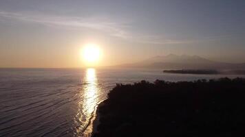 aéreo gili trawangan ilha lombok Indonésia com silhueta do montar rinjani em distância durante nascer do sol video