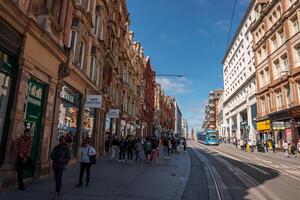 bullicioso Birmingham calle con histórico edificios y moderno tranvía foto