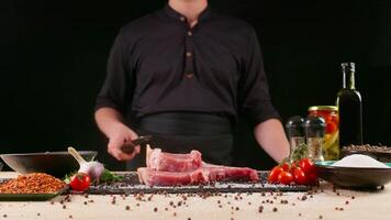 kookplaat voorbereidingen treffen vlees Aan professioneel keuken tafel met divers groenten 4k filmmateriaal. chef episch dropping rauw stuk van steak. video