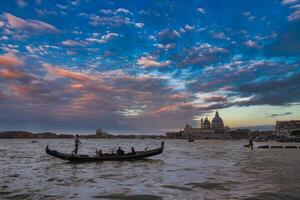 Traditional Venetian gondola floating on serene waters with city skyline in background photo