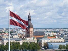 Panorama of Riga city with a big Latvian flag in foreground photo