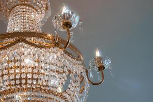 dorado cristal candelabro iluminado por velas en elegante y sofisticado habitación foto