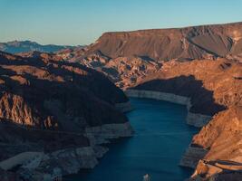 Hoover Dam on the Colorado River straddling Nevada and Arizona at dawn from above. photo