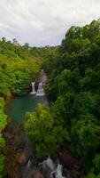 dinâmico fpv voar sobre rio e cachoeiras dentro a exuberante selva dentro Tailândia video