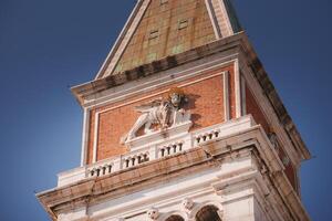 Urban architecture with lion statue on clock tower against clear sky photo