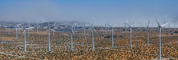 Vast Palm Springs Wind Turbine Farm Overlooking Arid Desert Landscape with Mountains and Clear Blue Sky photo