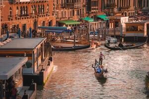 vibrante puesta de sol escena con góndolas deslizamiento mediante Venecia canal, Italia foto