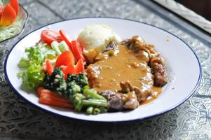 beef steak in gravy sauce or barbecued beef or grilled beef and mashpotato ,vegetable salad photo