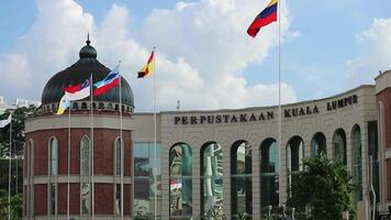 kuala lumpur, malaysia på Maj 22 2023. flera nationell flaggor flygande i främre av de kuala lumpur bibliotek byggnad. de bibliotek kan vara åtkomst förbi gående sydväst av de masjid jamek lrt station. video