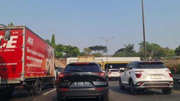 Jakarta, Indonesia on June 9 2023. Congestion occurs on the Jakarta Outer Ring Road Toll Road. Point of view of the car driver behind the Mazda CX-30, Innova and box ace hardware car. video