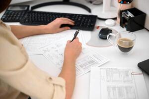 Portrait of a remote worker. An adult woman sits at a table in front of a computer and draws up a costly estimate. Confident young lady freelancer working from home. photo