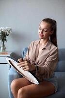 A creative female artist stands and works on a painting. A happy young lady is painting on canvas in her apartment. The concept of a young mother's leisure photo