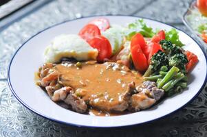 beef steak in gravy sauce or barbecued beef or grilled beef and mashpotato ,vegetable salad photo