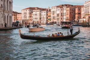 Iconic Gondola Navigating Grand Canal in Venice, Italy on a Sunny Day photo