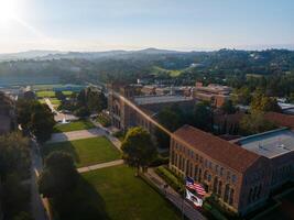 aéreo ver de americano Universidad instalaciones a amanecer con clásico y moderno arquitectura, verde espacios foto