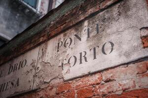 Vintage Reddish-Brown Brick Wall with Faded Ponele a Forno Sign  Venice, Italy Collection photo