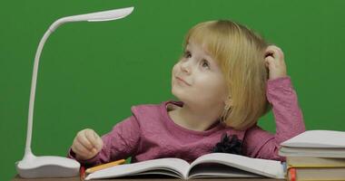 Child drawing at the table. Education process in classroom. Chroma Key photo