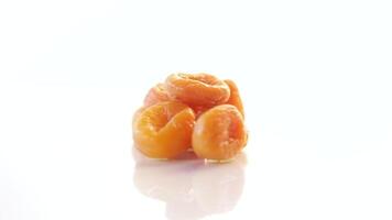 sweet delicious dried apricots in a bowl isolated on white background video