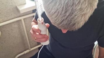 Man uses high frequency tool for hair and scalp treatment. Healthcare video