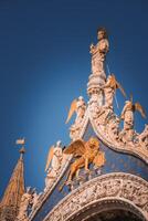 Ornate Renaissance-style building with angels and blue sky in Venice, Italy photo