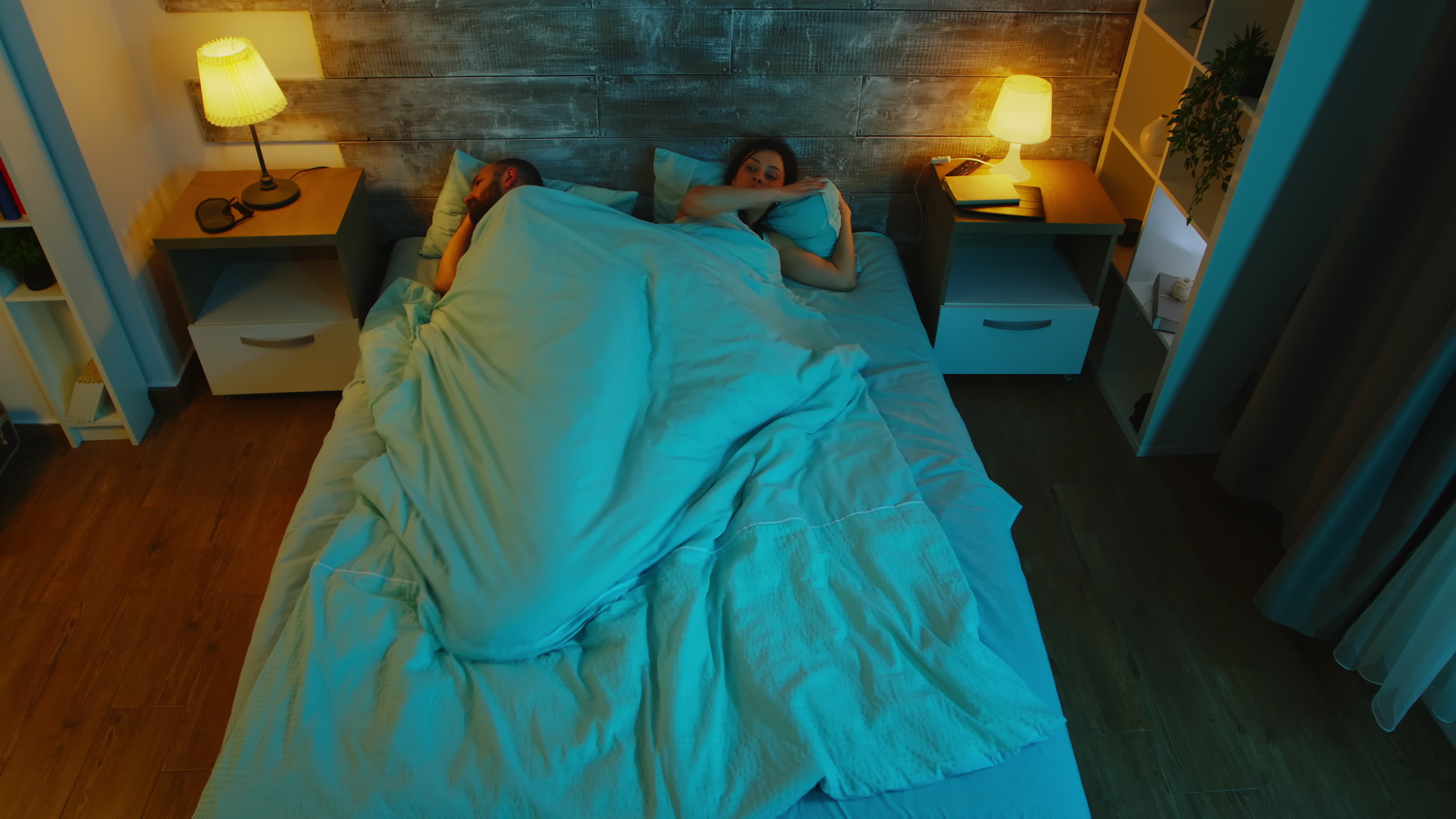 Top view of young couple under the sheets can't sleep after a