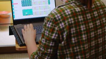 Back view of business woman typing on laptop while working from home during coronavirus isolation. video