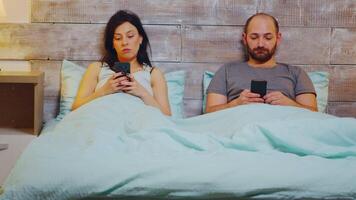 Zoomen im Schuss unter das Decke im Bett mit Smartphone Vor Schlafen. video