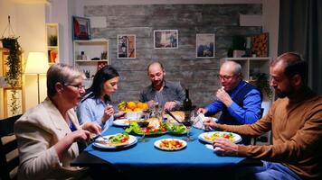 barbuto giovane uomo godendo il suo delizioso cena con il famiglia. video