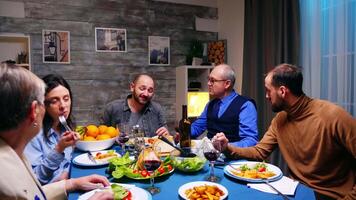 Due figli maschi avendo un' conversazione con loro padre a cena. delizioso cibo. video