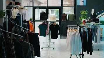 Shopping mall prepared with stock of new fashion collection line, multiple racks with fashionable wear and modern accessories. Empty clothes showroom with trendy items, small business. Camera B. video