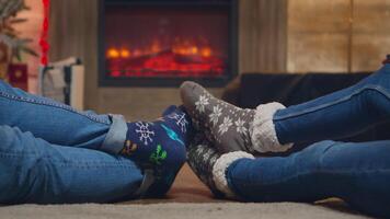 Pareja vistiendo de lana calcetines en frente de hogar en Navidad día. casado Pareja. video