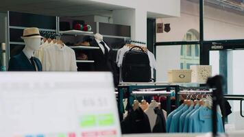 Empty fashion store selling modern clothing and accessories, having trendy shoes and bags on showroom display. Interior of fashionable clothes shop, stands with shirts and pants on racks. Camera A. video