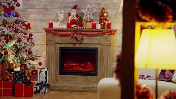 Presents under a christmas tree with lights and fireplace burning. video