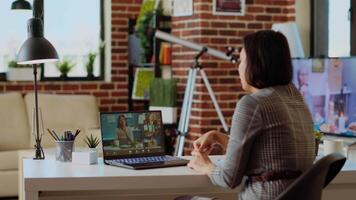 Remote professional holding q and a session with webinar participants via videoconference meeting in cozy apartment. Online videocall host engaging in online discussions with trainees, camera B video