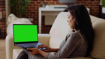 Person checking emails on isolated screen laptop during work from home. Indian woman in cozy bright apartment doing job tasks, reading business messages on chroma key notebook video