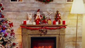 Candles burning on top of fireplace in a room decorated for christmas holiday. video