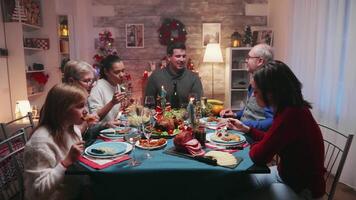 Christmas eve celebration of a big family with traditional food. Winter holidays celebration. Traditional festive christmas dinner in multigenerational family. Enjoying xmas meal feast in decorated room. Big family reunion video