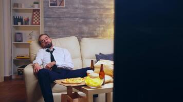 Young businessman in suit falling asleep on the couch still dressed in suit video