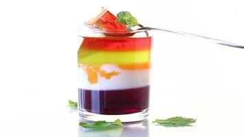 lot of colored sweet fruit jelly in a glass isolated on white background video