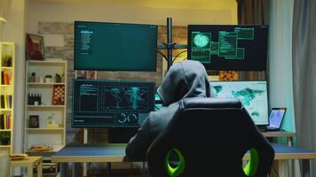 hacker vestindo uma moletom com capuz enquanto comprometendo cyber crimes a partir de dele apartamento. video