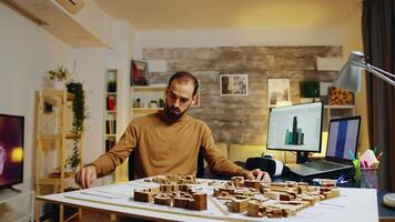 Young architect using augmented reality holograms for his building models. video