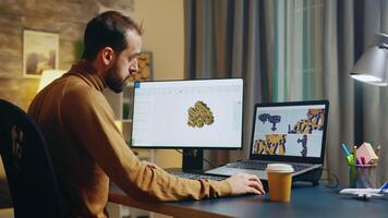 Bearded engineer taking a sip of coffee while working on computer. Gears production. video