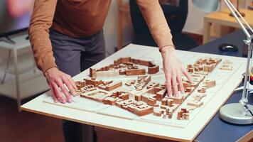 Male architect working on construction of a new city. Building models. video