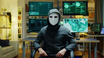 Dangerous hacker hiding his identity wearing a white mask while using augmented reality to steal confidential data. video