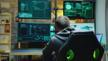 Bearded hacker turning and looking into the camera while breaking a firewall. video