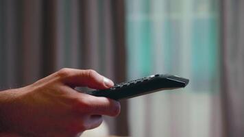 Close up of businessman using tv remote control while resting in living room. video