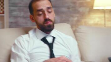 Businessman relaxing at home drinking beer and eating chips. video