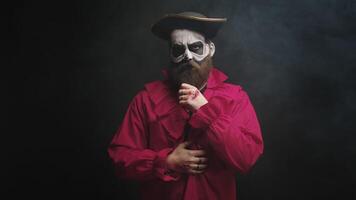 Mann gekleidet oben mögen ein unheimlich Pirat im rot Hemd und mit ein Hut zum Halloween Über schwarz Hintergrund. video
